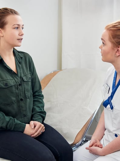 En sjuksköterska pratar med en kvinna.
