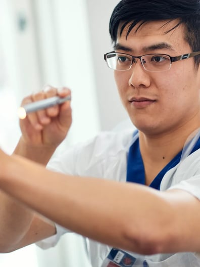 En sjuksköterska undersöker synen hos en patient med en lampa.