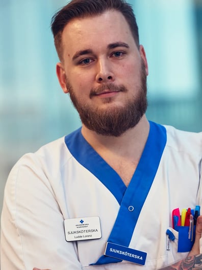 En sjuksköterska tittar in i kameran och ler.