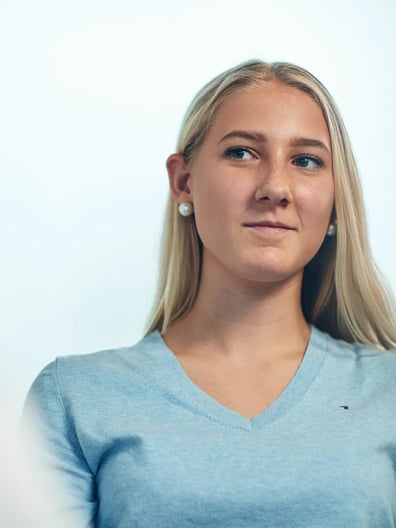 En kvinna i blå tröja pratar med en man.