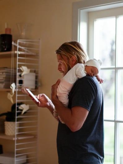 En man som håller en bebis i famnen.