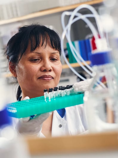 A woman in a lab holding a toothbrush.