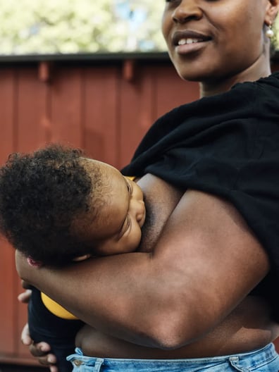 En kvinna med ett spädbarn i famnen.
