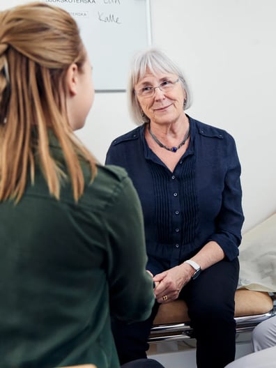 En grupp kvinnor som sitter runt ett bord och pratar med varandra.
