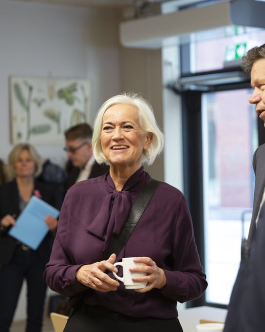 En grupp människor som står och pratar med varandra.