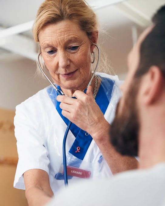 En kvinna med stetoskop pratar med en man.