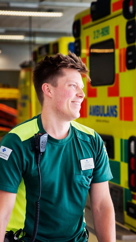 En man står framför en gul ambulans.