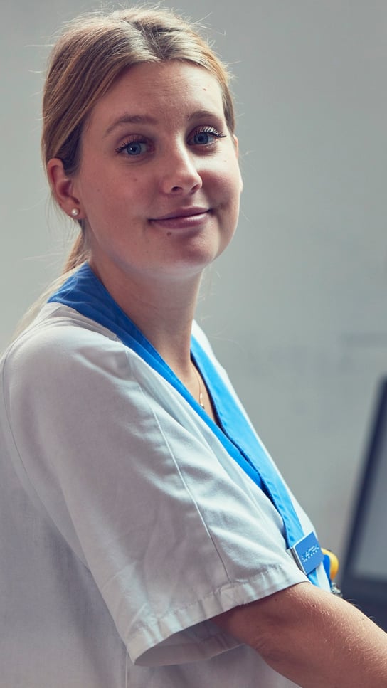 En kvinna i operationskläder står bredvid en kvinna i vit skjorta.