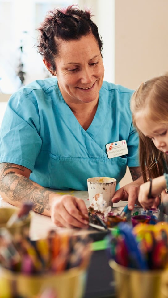 En kvinna och en liten flicka sitter vid ett bord.