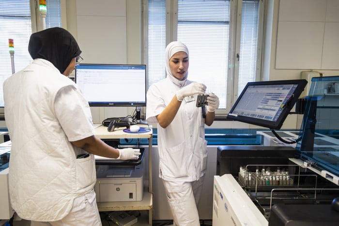 Sjukvårdspersonal står i ett laboratorium