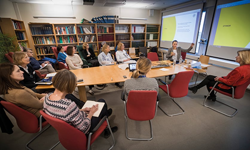 Flera personer sitter runt ett konferensbord