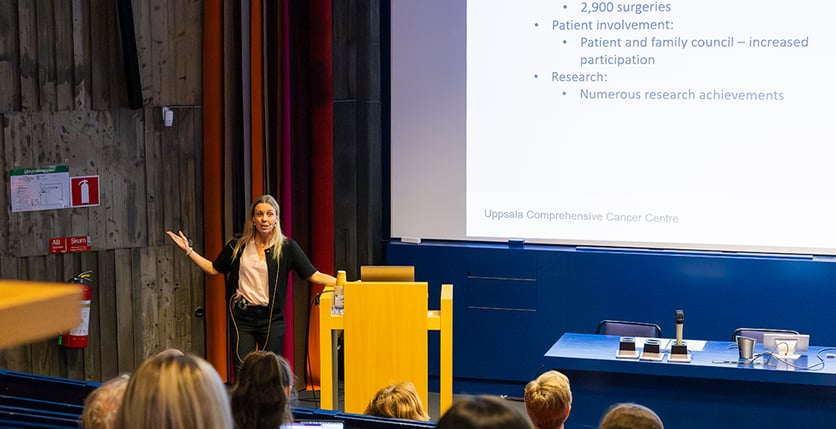 Kvinna står på scen och talar vid podium
