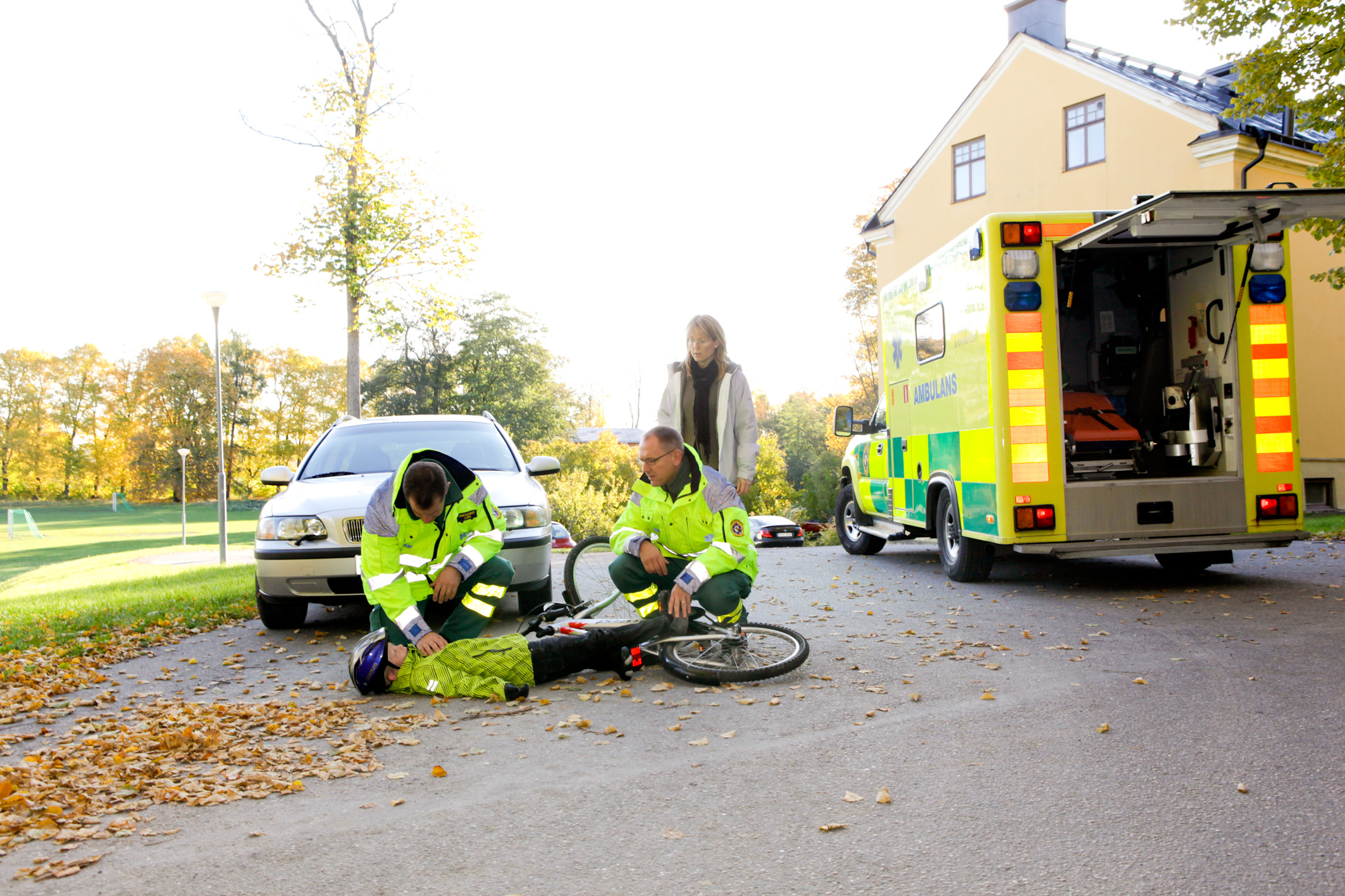 Ambulanspersonalen undersöker pojke på marken.