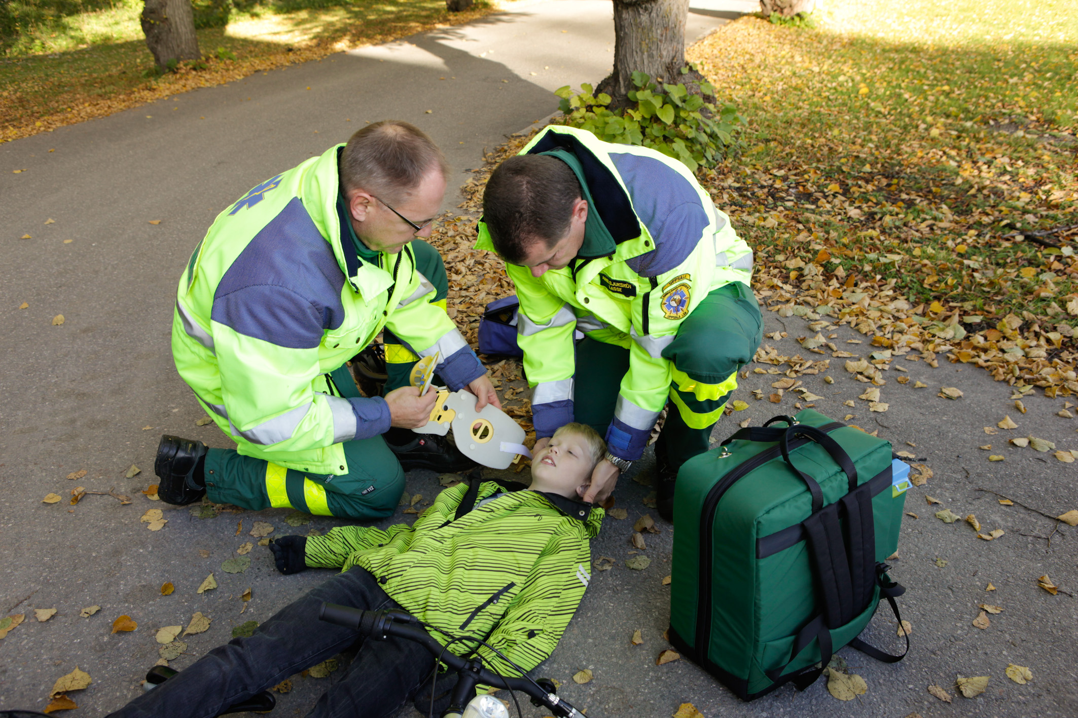 Ambulanspersonalen pratar och undersöker pojken.