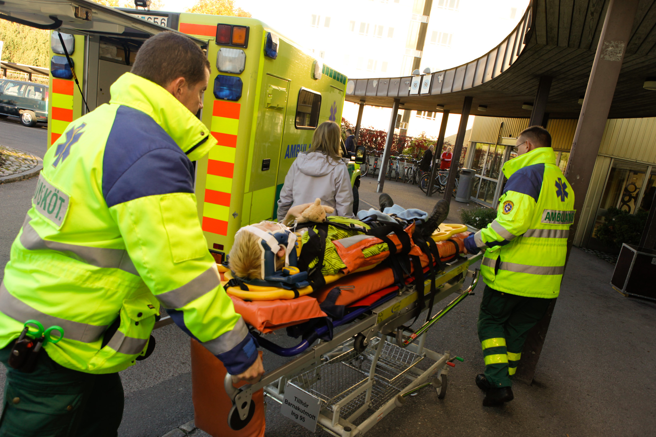 Ambulanspersonalen drar pojken från ambulansen in till barnakuten.