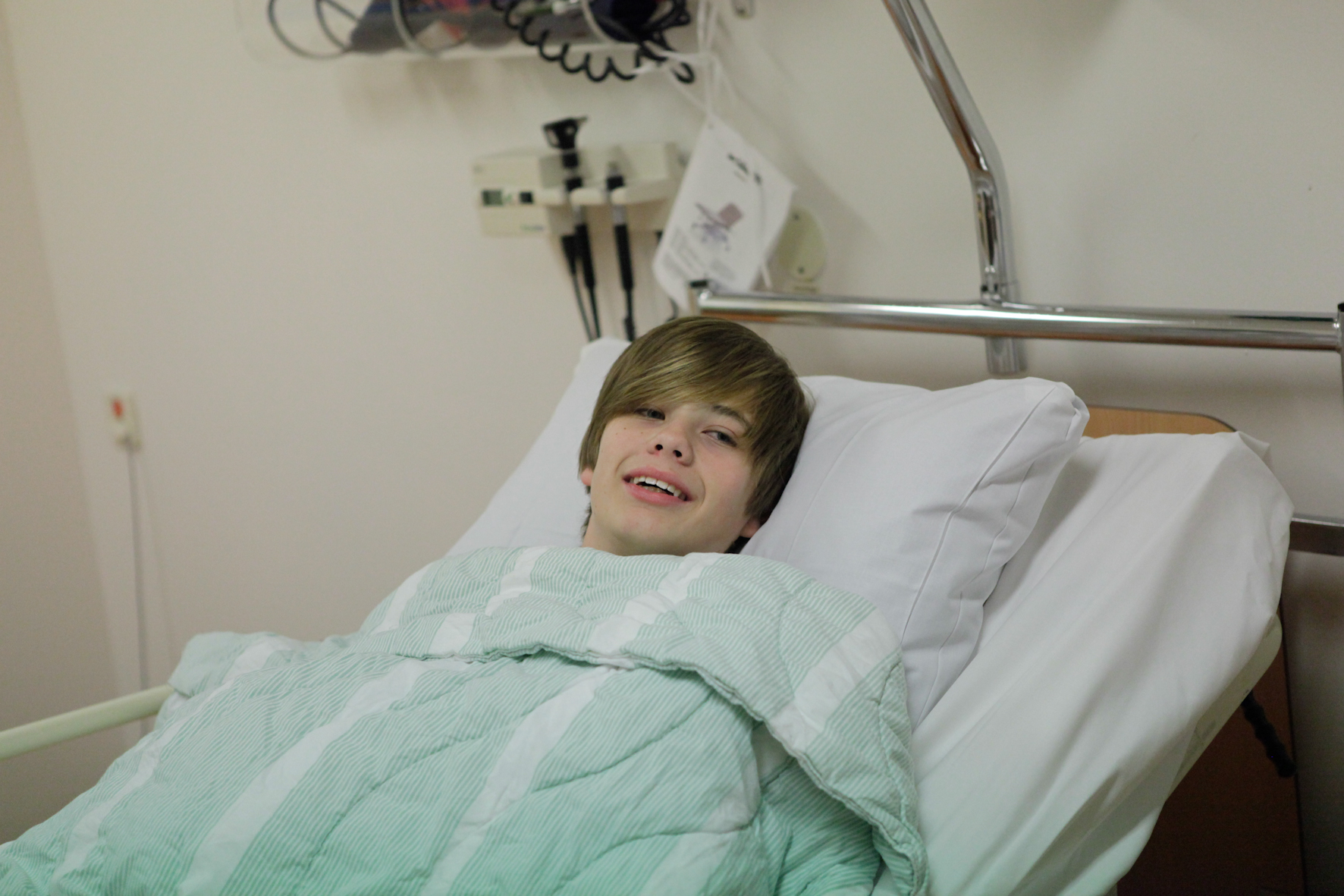 Pojke ligger i sjukhussäng.