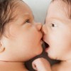 Två nyfödde bebisar ligger med ansiktena mot varandra