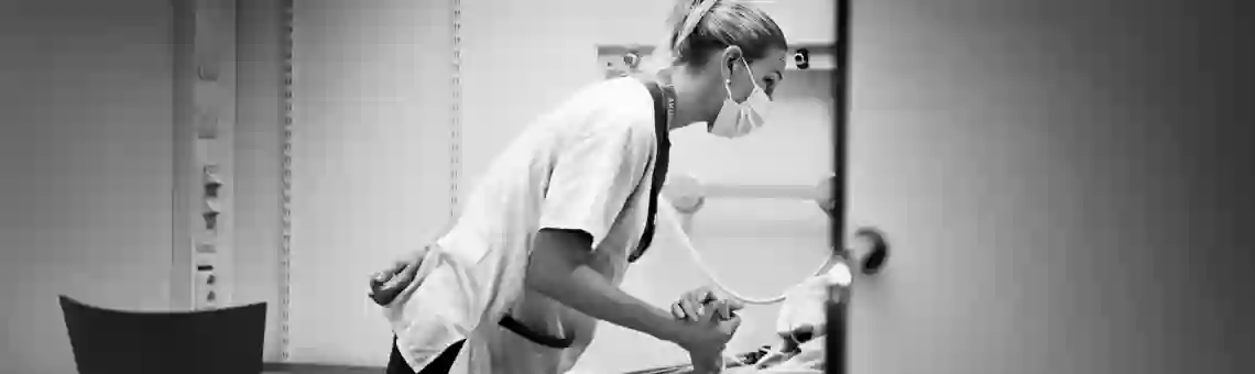 En undersköterska håller en patient i handen